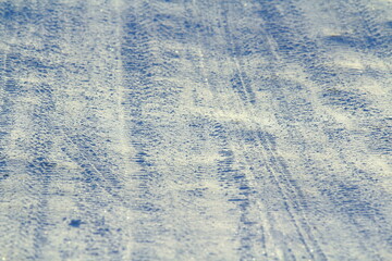 Tire tracks left in the snow on a bright sunny day