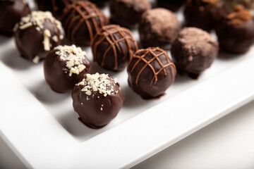 variety of handmade gourmet chocolate truffle candy on a white plate