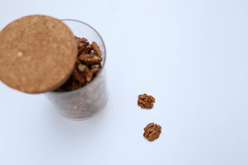 Walnuts. Peeled halves on white. In jar Top view. Place for text