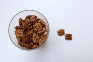 Walnuts. Peeled halves on white. In jar Top view. Place for text
