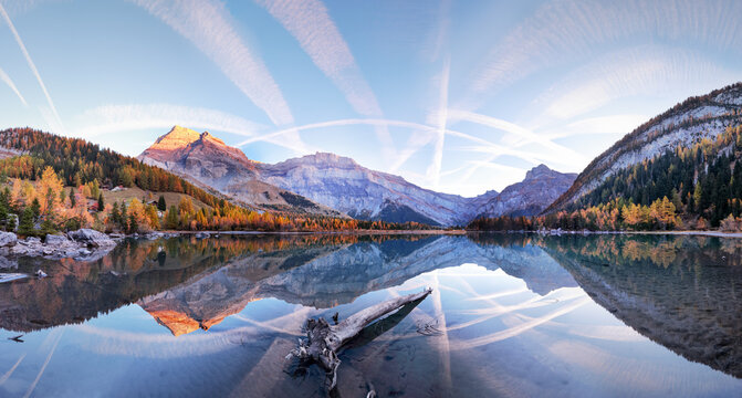 Spectacular scenery of lake with smooth surface reflecting amazing mountain range and sky