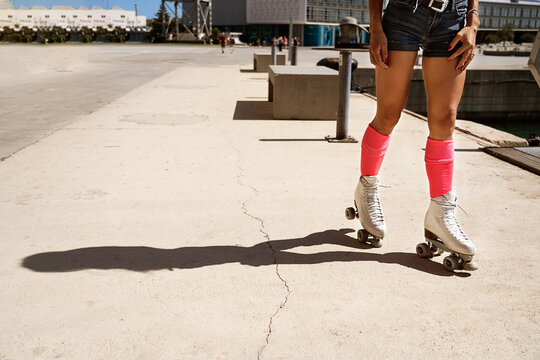 Concentrated female roller skating on sports ground on sunny day in city