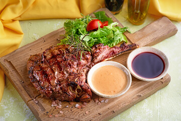 Medium Ribeye steak with spices on the wooden tray. Steak beef. Beef steak medium withwith mix salad.