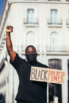 Man protesting at a rally for racial equality holding a "Black Power" poster. Black Lives Matter.