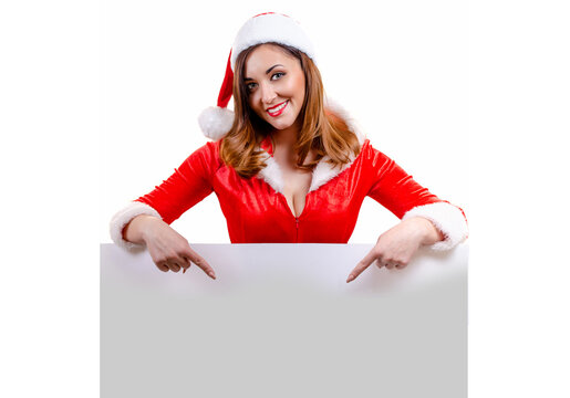 Portrait of an exciting young girl dressed for Christmas points a finger below into empty board space advising blockbuster sale discount or message. Copy space. Red Santa Suite, Isolated