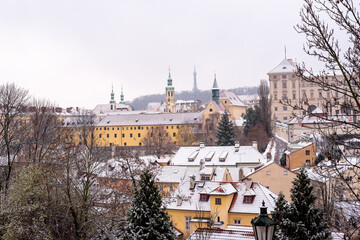 Classic fairytale winter view on old Prague over snow capped roofs, Christmas time in Czech Republic. 