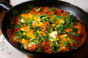 Fototapeta na wymiar Fried eggs with tomatoes in a pan