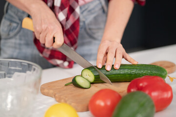 Close up. Young woman cutting ingredients on table cooking a lunch or dinner standing in the kitchen. Healthy food living. Healthy lifestyle.
