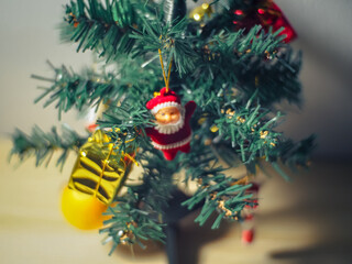 Small Christmas tree decorate with Santa Claus doll and gift on white background