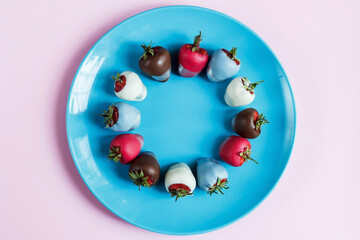 Strawberries in chocolate on a blue plate and pink background, dessert for Valentine's Day, romance, food gift. Homemade red strawberries in chocolate. Postcard with a romantic dessert with free space