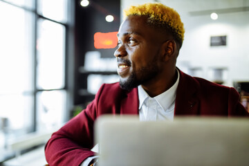 afro american man in marsala jacket remote work in living room at home