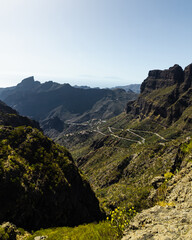 Fototapeta na wymiar Green mountain hills and winding road near Masca village on a sunny day, Tenerife