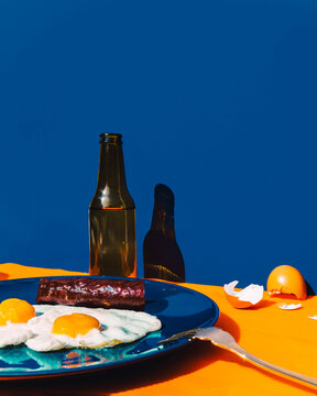 Bottle of beer and plate with fried eggs and chorizo
