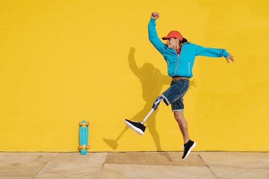 Happy Disabled Man Walking Against Yellow Wall