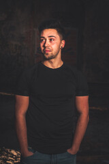Naklejka premium Young caucasian man posing inside an abandoned building.