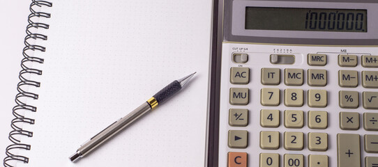 business, education, people and technology concept - close up of with calculator, pen and notebook on table