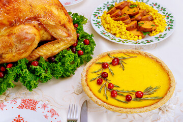 Christmas dinner with pumpkin pie. Roasted turkey garnished cranberries and kale.