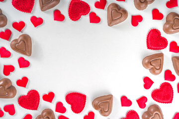Red hearts, gift with ribbon and chocolates hearts flat lay, Valentine day and love background. Valentine's hearts ornament on white backdrop copy space top view
