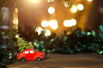 Christmas decor - red retro car carries Christmas tree with gift boxes on roof. space for text. New...