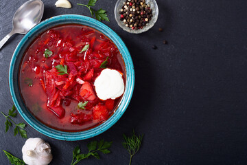 Homemade bowl with borscht and herbs