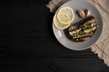 Sandwich with sprats. Sprat in oil. On a black background