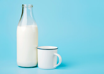 milk in a glass bottle and a white cup