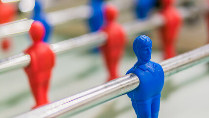 Red and blue table football player on steel rod isolated, GREEN BACKGROUND