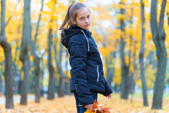 a girl posing and enjoying autumn in city park, beautiful nature with yellow leaves