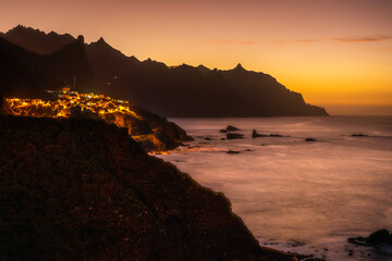 Fototapeta premium sunset at the coast of island tenerife with village at the mountain coast