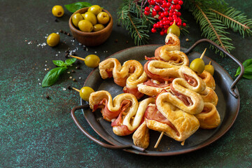 Christmas snack Christmas tree with olive and bacon and christmas decor on a slate tabletop. Christmas and New Year background for food.