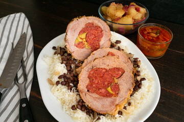 Boliche (Cuban Pot Roast): Roast beef stuffed with chorizo sausage and olives served on a platter of black beans and rice