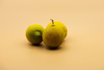 three lemons photographed in studio on beige background
