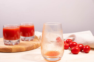 tomato juice in a glass and tomatoes