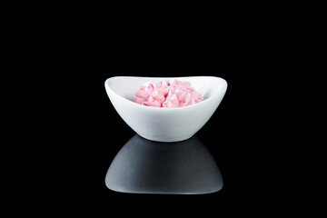 White crockery with sauce on a black background with reflection.