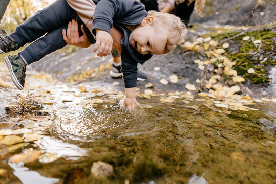 little baby play with water in puddle