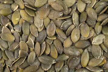 Top closeup view of squash seeds. Food backdrop