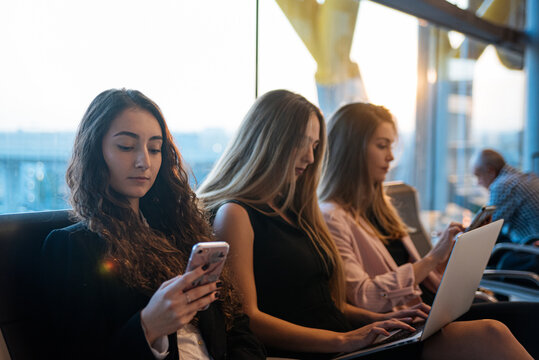 Female entrepreneurs using gadgets in airport