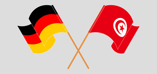 Crossed and waving flags of Germany and Tunisia