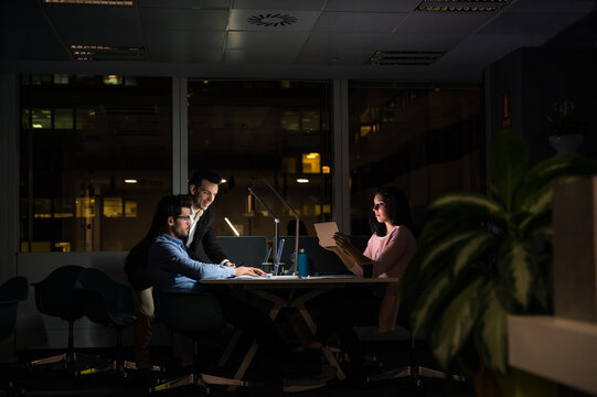 Cheerful young group of colleagues working late in office - Powered by Adobe