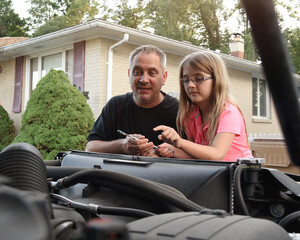 Father and Daughter Together Looking at Car