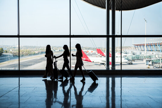 Anonymous women walking near airport window