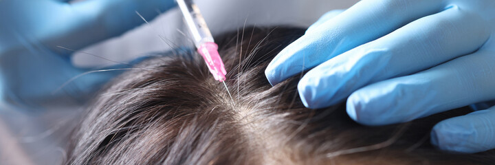 Trichologist makes an injection into scalp closeup