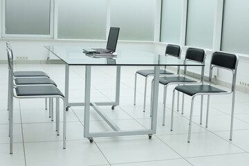 Black chairs glass table stethoscope laptop in office space