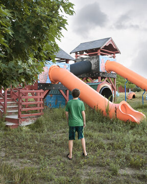 Boy Looking at Old Abandoned Playground