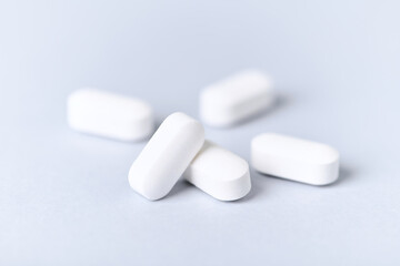 Carnitine tablets. Concept for a healthy dietary supplementation. Bright paper background. Soft focus. Close up.