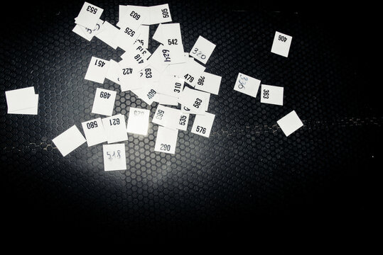 sheets with numbers scattered on the black floor