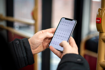 Crop man using smartphone in public transport