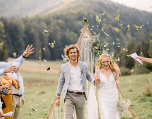 guests sprinkle petals on the newlyweds after the wedding ceremony