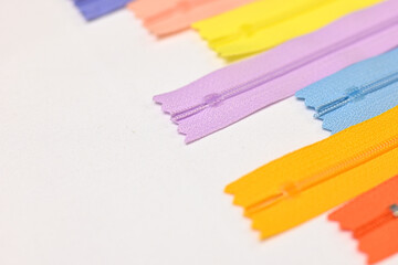 Texture of colourful zippers together for sewing, flat lay against white background, empty space