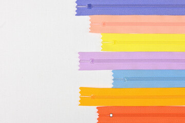 Texture of colourful zippers together for sewing, flat lay against white background, empty space